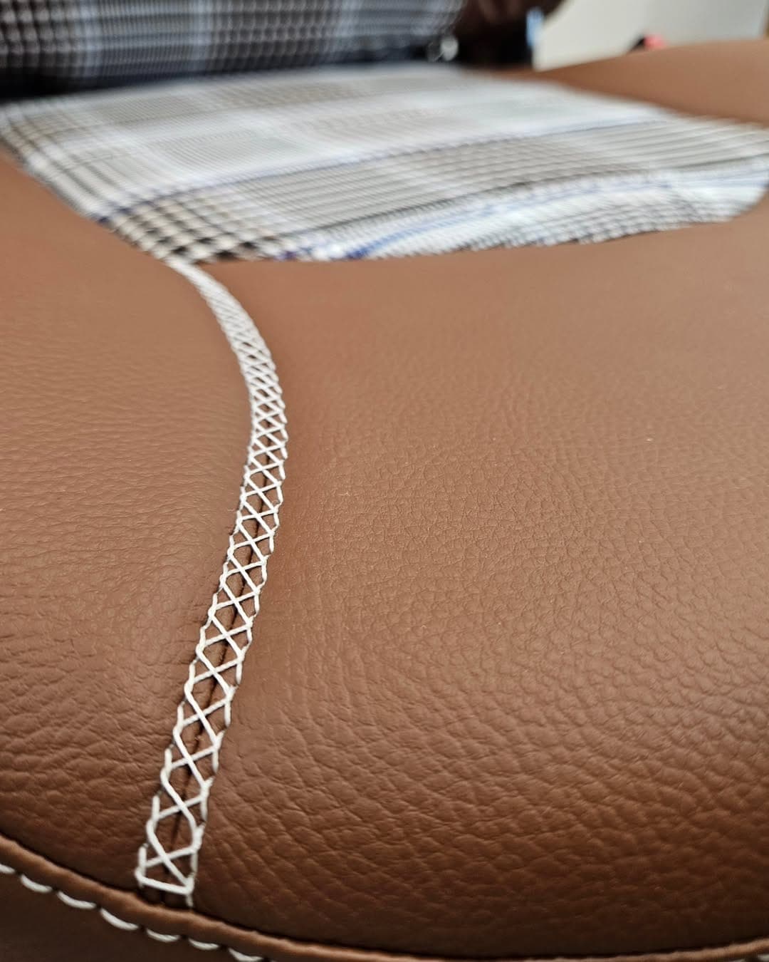 Détail d'un siège mêlant cuir, simili et tissu après réfection